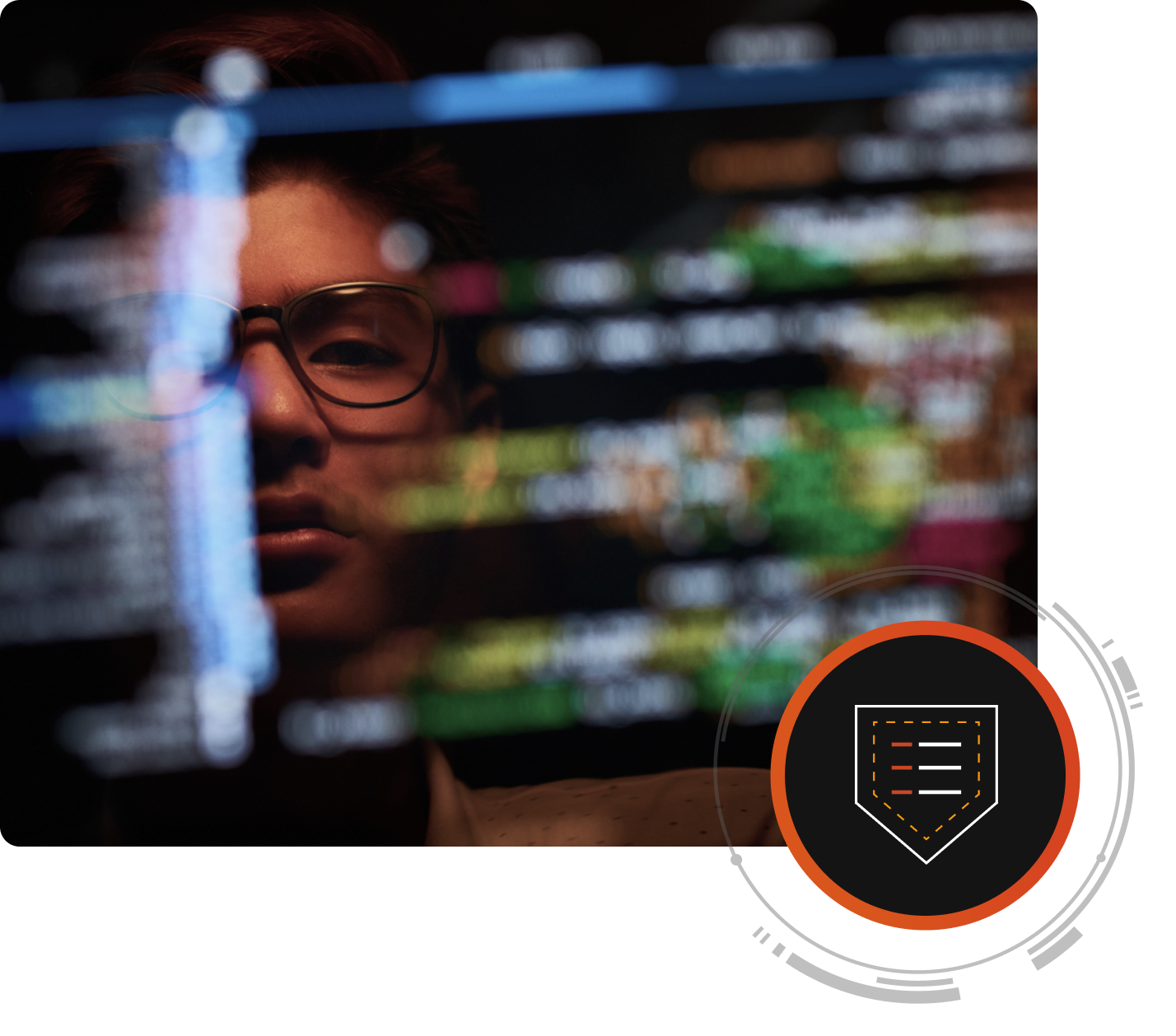 A person's face is reflected on a computer screen with cybersecurity code.